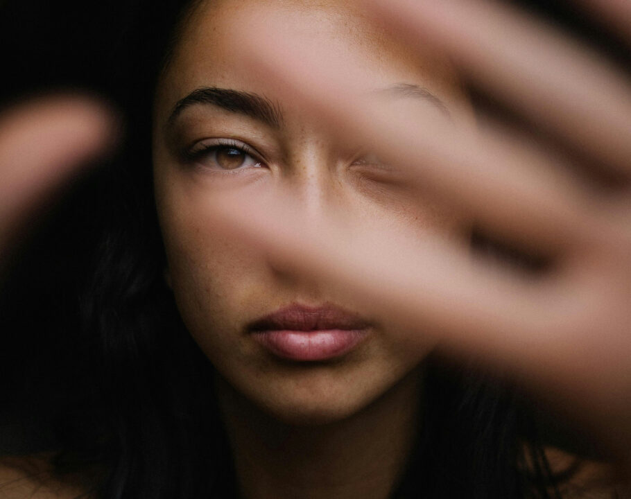 woman in dark with hands at camera